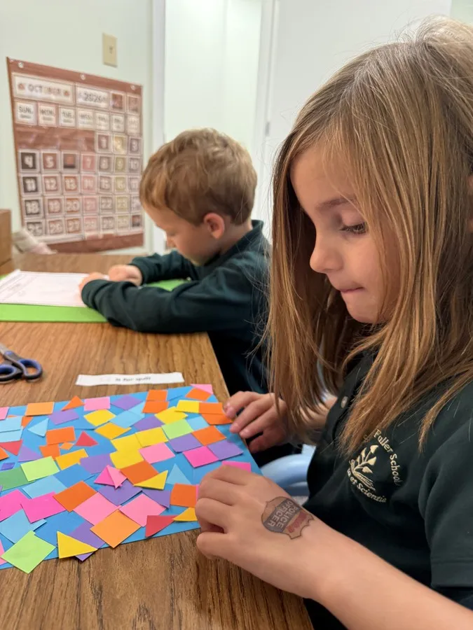 A student building a pattern with colored paper squares