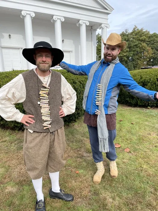 Two faculty members in period costume on the school lawn