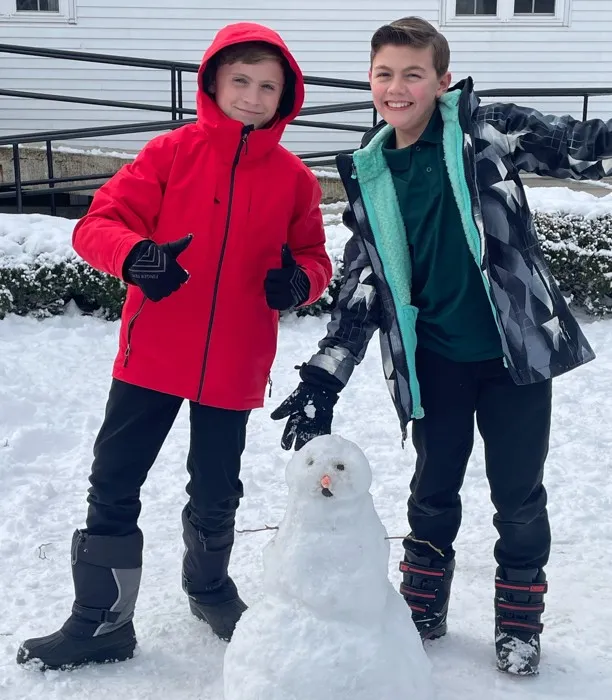 Two students playing in the snow