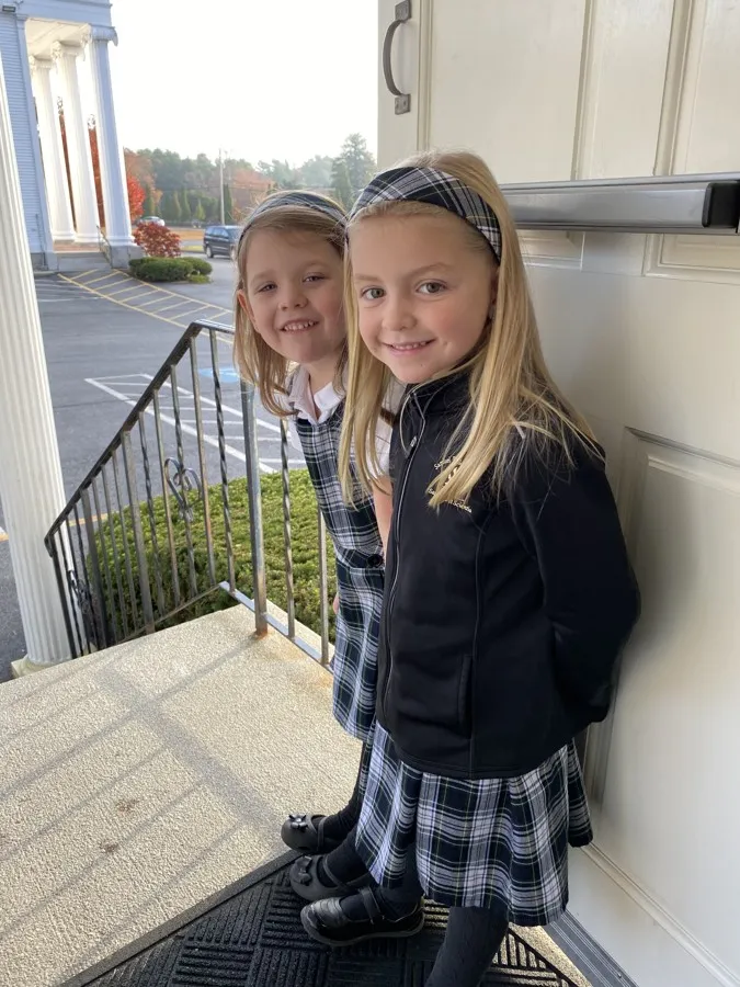 Two young students on the school steps